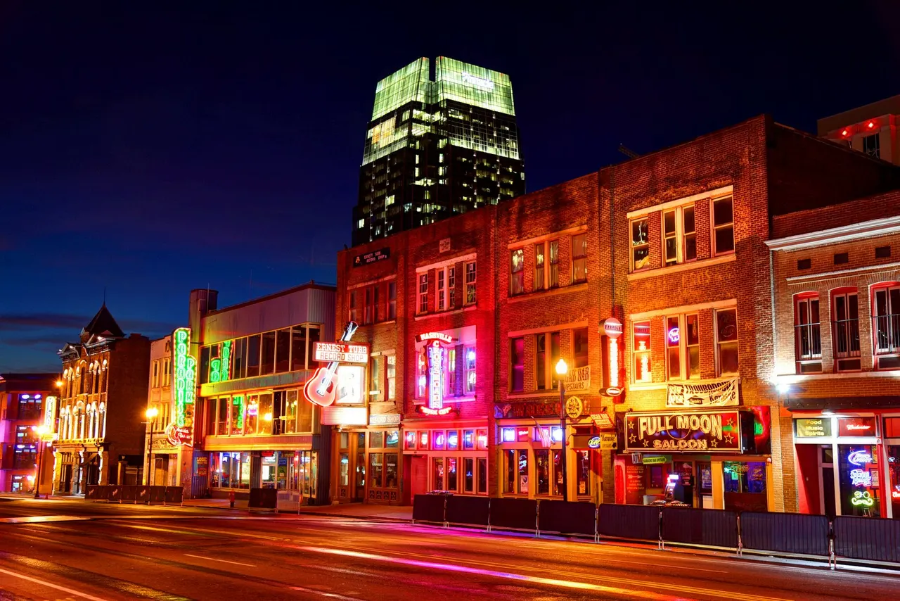 Beale Street de Memphis de noche, con los rótulos de neón de los locales de música encendidos a lo largo de la calle.