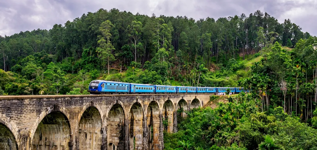 Tren azul cruzando el Puente de los Nueve Arcos entre la vegetación, Ella (Sri Lanka)